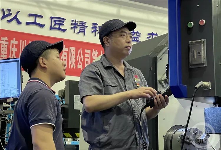 ▲劉平(右一)在給徒弟演示設(shè)備操作 ▲劉平(右一)在給徒弟演示設(shè)備操作